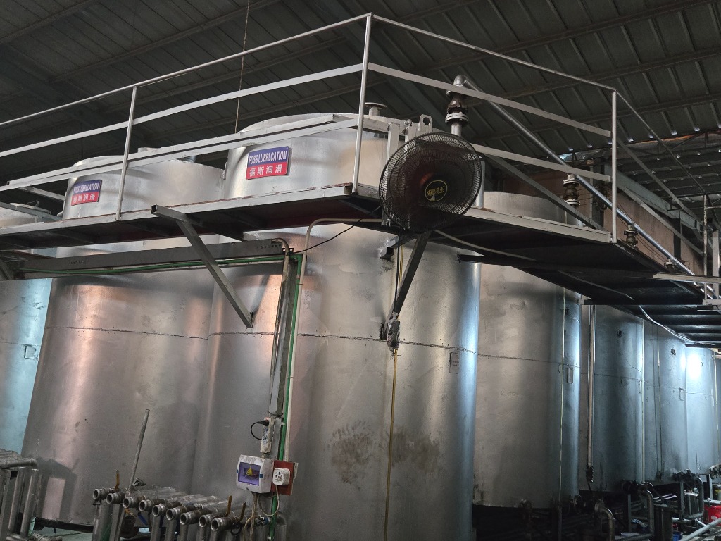 Stainless steel automated blending kettles with FOSS LUBRICATION 福斯润滑 signage and manifold piping