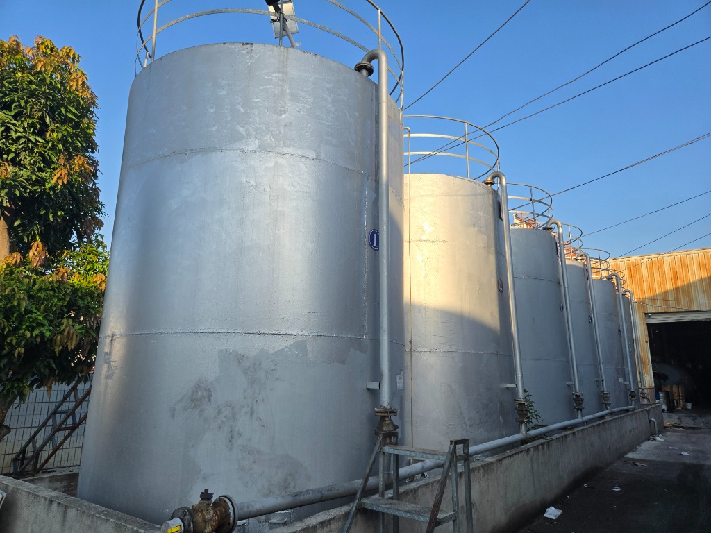 Outdoor bulk base oil storage silos numbered 1 to 4 with vertical inlet piping and access ladders